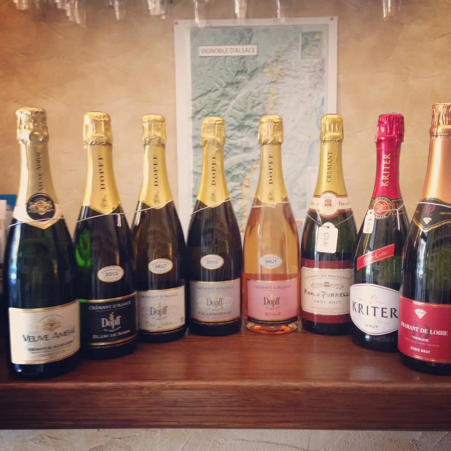 Una fila di Crémant e bollicine francesi sul bancone