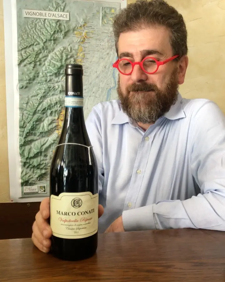 Il Professore con gli occhiali rossi e una bottiglia, davanti alla carta dei vigneti