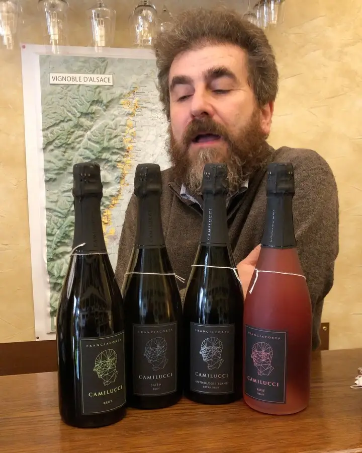 Il Professore dietro quattro bottiglie di Franciacorta