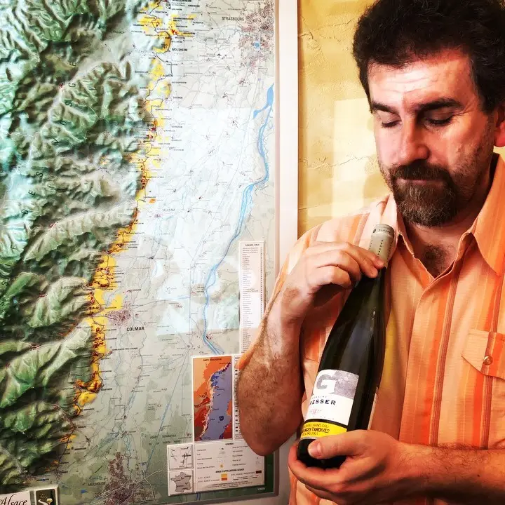Il Professore con una bottiglia di Rémy Gresser davanti alla carta dei vigneti d’Alsazia