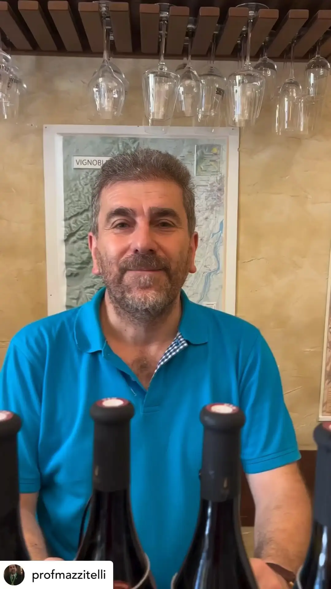 Il Professore davanti alla carta dei vigneti, con le bottiglie in primo piano